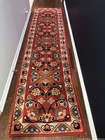 Full length view of wool runner rug with floral pattern placed on hardwood floor
