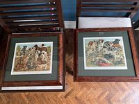 Two framed dog breed prints side by side on chairs, showing full frames and prints.