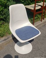 Front view of the vintage tulip chair showing white fiberglass body and blue cushioned seat.
