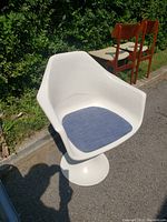 Side view showing overall shape, pedestal base, and blue seat cushion.