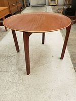 Three-quarter view of assembled tray table showing round top and curved X-frame base