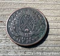 Obverse of the 1844 Bank of Montreal half penny coin showing the bank's emblem and denomination.