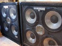 Pair of speaker cabinets side by side showing fronts and metal grilles