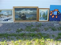 Wide view of all four paintings set outdoors on gravel showing relative sizes and frames.