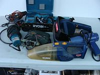 Lot of 8 assorted power tools arranged on table