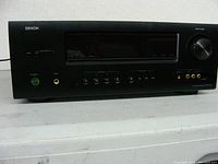 Front view of the Denon AVR-1312 AV Surround Receiver showing power button, volume knob, multiple audio input ports and control buttons.