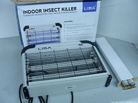 Image of LIBA indoor insect killer unit with two fluorescent light tubes, protective grill, and original box behind it