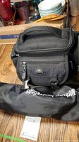 Black Samsonite camera case and black Merkury Innovations tripod in carrying bag