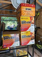 Two unopened boxes and one opened box of Duraflame Quick Start fire starters stacked, showing packaging and firelighter count.