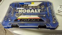 Closed view of Kobalt Pro 90 63 pieces mechanic tool set in blue case with clear lid showing contents.
