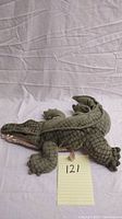 Side top view of the Folkmanis alligator puppet showing overall body shape, scale texture, claws and mouth.