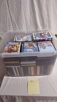 Plastic storage bin filled with DVDs, some box sets visible on top: Ice Age, Horton Hears a Who, and others.