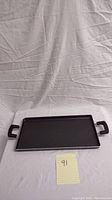 Full view of the rectangular griddle pan showing the non-stick surface, two side handles, and overall shape.