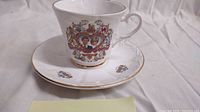 Commemorative teacup and saucer set featuring portraits of Lady Diana and Prince Charles with gold trim on white fine china.