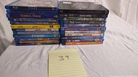 Stacked Blu-ray movies showing 23 titles, mostly kids and family movies from various studios including Disney and Universal