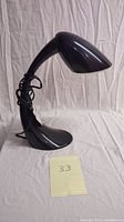 Side angle showing the overall curved design and profile of the black Verilux Smartlight lamp with power cord coiled on neck.