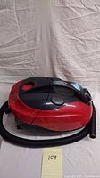 Side view of red and black H20 Turbo vacuum including hose and control buttons on top