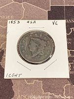 Obverse side of 1853 US Braided Hair Large Cent copper coin with Lady Liberty head, stars and date 1853.