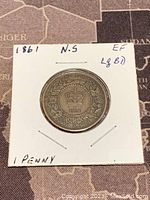 Reverse side showing crown, date, and floral wreath with Nova Scotia inscription on 1861 one penny coin.