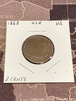 Obverse side of the 1868 US Two Cent copper coin showing date and detail through a 2x2 holder.