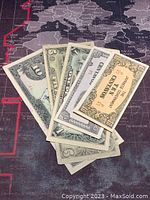 Five Japanese Government-issued Philippine banknotes fanned out showing front sides with various denominations including 5 and 10 pesos.