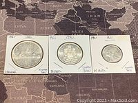 Top view of the front (obverse) sides of the three coins, showing dated year 1961 and silver content marked on the holders.