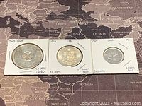 Three Canadian silver coins from 1964, including 1 dollar, 50 cents, and 25 cents, each mounted in protective holders labeled with year, denomination, and silver content.