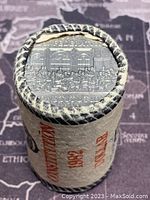 End view of the roll showing the detailed image on the 1982 Canadian Constitution silver dollar coin inside the roll.