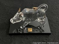 Side angle showing glass bull with gold-accented horns and hooves on black base with CIBC logo.