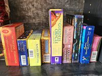 Photo showing nine tarot and oracle card decks lined up side by side in their boxes against a rustic background.