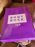 Purple box labeled Body Rock 12 lb, showing original packaging of the weighted vest.