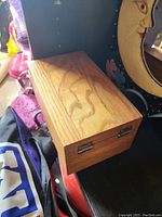 Closed wooden card box showing natural wood grain and metal hinges