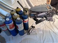 Photo showing BernzOMatic torch connected to a propane cylinder with additional used propane cylinders behind it.