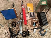 Wide view of entire assortment showing tripod, light box, cords, film holders, splicer, and other items.