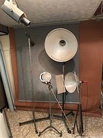 Photographic lighting stands with mounted reflectors, showing overall setup and scale