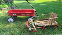 Red Radio Flyer wagon and vintage wooden American Racer sled on grass, showing full lot contents.