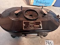 Top and front view showing the metal nameplate, two turn knobs labeled 'TURN' and circular aperture on the lid.