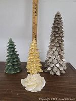 Lot of 4 assorted decorative candles including three tree-shaped and one rose-shaped candle.