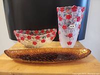 Lot overview with three decorative glass items on wooden surface