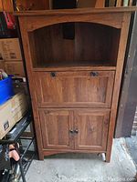 Front view of wooden cabinet showing open top shelf, fold-down middle compartment closed, and closed double-door bottom cabinet