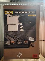 Cardboard retail packaging box displaying branding and product name for Husky Liners Weatherbeater floor liners with protection claims and fitment info.