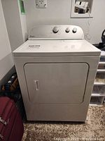 Front view of white Whirlpool electric dryer with door closed