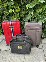 Full view of three luggage pieces: red Tommy Hilfiger suitcase, brown Samsonite suitcase, and black carry-on bag.