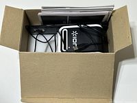 View of boxed ION scanner and accessories with cables and manual visible.