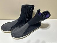 Pair of Akona black neoprene booties with grey rubber sole and side zipper