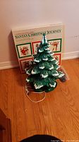 Full view of ceramic Christmas tree with peg lights and puzzles box behind