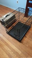 Wide view showing dog crate and animal carrier side by side on the floor.
