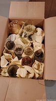 Box containing multiple various glasses of different shapes, colors and sizes.