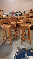 Four wicker bar stools shown from front and side