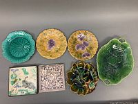 Top view showing seven pieces: leaf tray, yellow plates, green leaf plate, two tile trivets